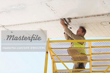 Aircraft worker repairing airplane