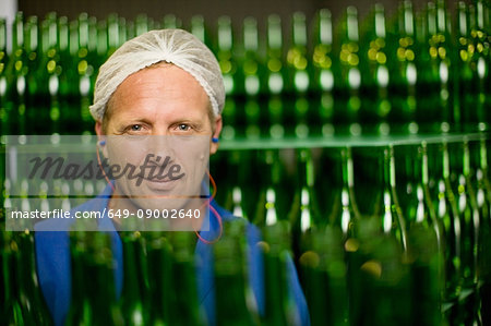 Worker standing in bottling plant