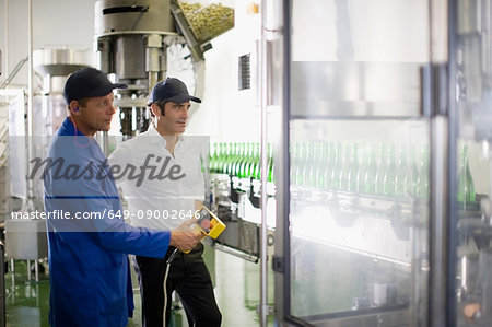 Workers operating machinery in factory