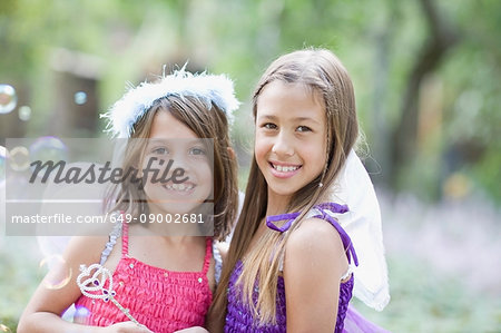 Girls blowing bubbles in fairy costumes