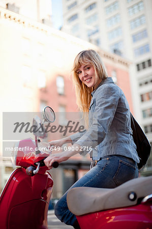 Woman with scooter on city street