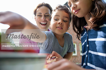 Mother and children eating outdoors