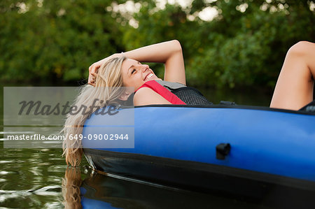 Woman relaxing in kayak in creek