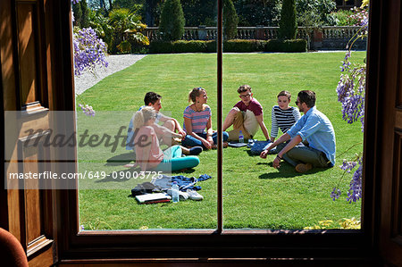 Friends relaxing on manicured lawn
