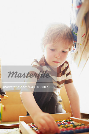 Boy playing with abacus indoors