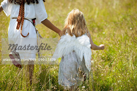 Girls in costumes walking in field