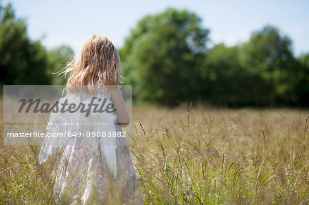 Girl wearing angel wings in field