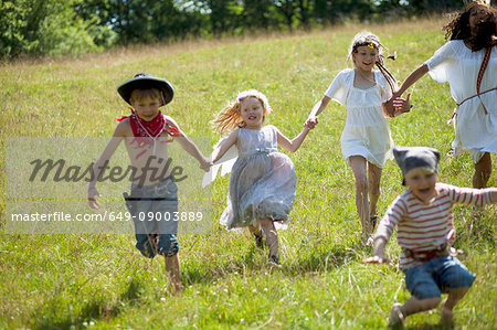 Children in costumes running in field