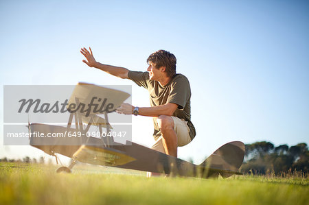 Man playing with toy airplane in park