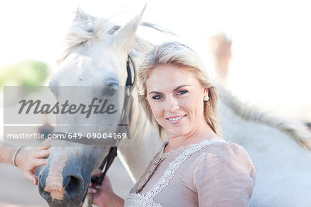 Mid adult woman holding horse's bridle