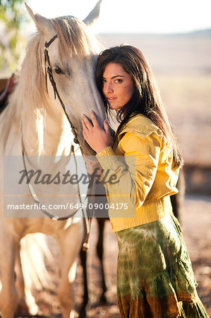 Young woman touching horse's face