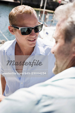 Two men on yacht, one wearing sunglasses