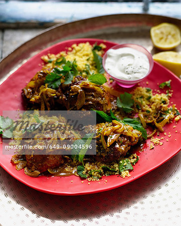 Plate of harissa chicken with couscous and mint yogurt
