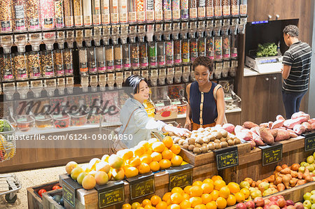 Young women grocery shopping, browsing produce in market