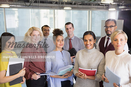 Portrait smiling business people with paperwork in conference room