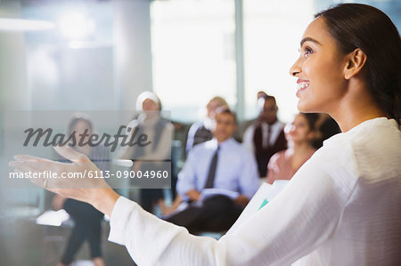 Smiling businesswoman leading conference presentation