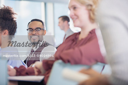 Smiling businessman listening in conference audience