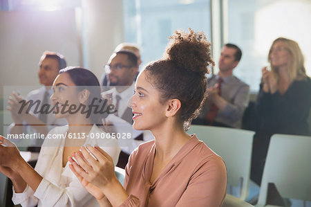 Businesswomen clapping in conference audience