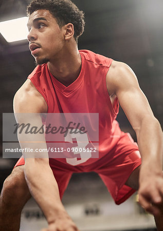 Determined young male basketball player dribbling the ball