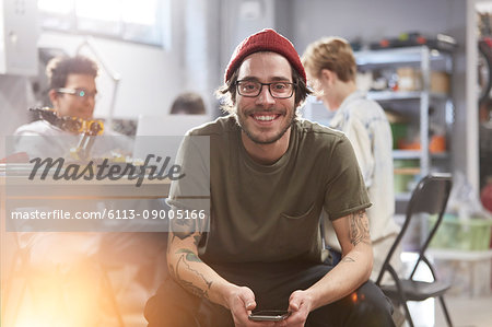 Portrait smiling confident male designer with cell phone