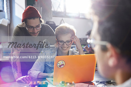 Designers working at laptop in workshop