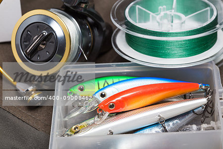 Closeup of a fishing box with colorful lures. Focus on red wobbler.