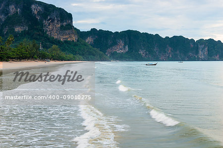 Thai wooden boat on the waves in the bay of Krabi resort, Thailand