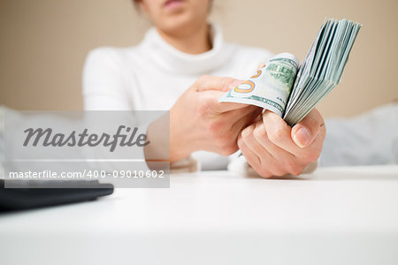 business, finance, saving, banking and people concept - close up of woman hands counting us dollar money