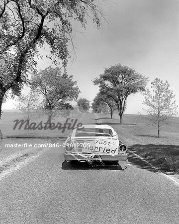 1960s JUST MARRIED BRIDE AND GROOM DRIVING AWAY IN CAR