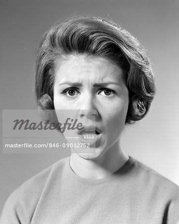 1960s BRUNETTE WOMAN WITH SHOCKED ANGRY SERIOUS FACIAL EXPRESSION LOOKING AT CAMERA