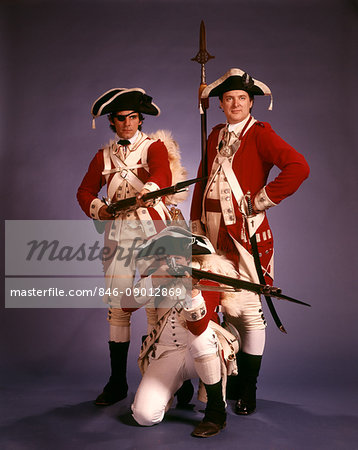 1970s 1776 AMERICAN REVOLUTION HISTORICAL REENACTORS WEARING BRITISH RED COATS OFFICER AND TWO SOLDIERS WITH FLINTLOCK MUSKETS
