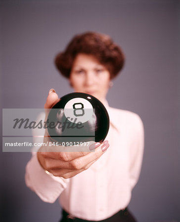 1970s WOMAN STANDING BEHIND HOLDING AN EIGHT BALL LOOKING AT CAMERA 1970s WOMAN STANDING BEHIND HOLDING AN EIGHT BALL LOOKING AT CAMERA
