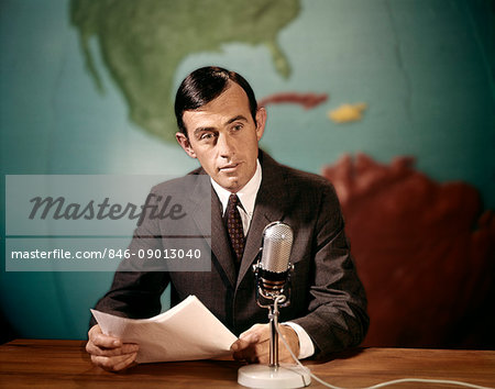 1960s NEWSMAN NEWS ANCHOR READING NEWS FROM PAPERS SPEAKING INTO MICROPHONE LOOKING AT CAMERA