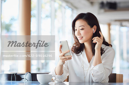 Japanese woman with smartphone in a stylish cafe