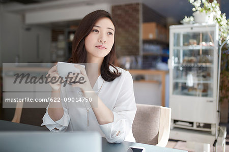 Japanese woman with laptop in a stylish cafe