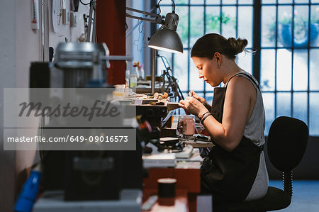 Female jeweller at work in jewellery workshop