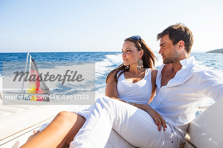 Couple relaxing on yacht, on water, looking at view