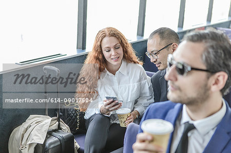 Young businesswoman and man looking at smartphone on passenger ferry