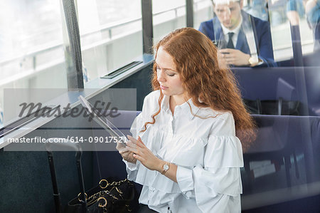 Young businesswoman looking at digital tablet on passenger ferry