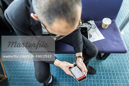 Businessman on passenger ferry looking at smartphone