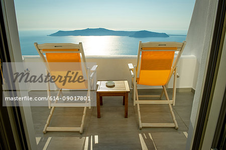 Deckchairs on balcony with view of sea, O'a, Santorini, Kikladhes, Greece