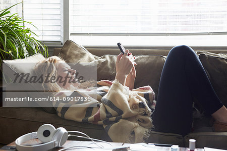 Woman texting on sofa