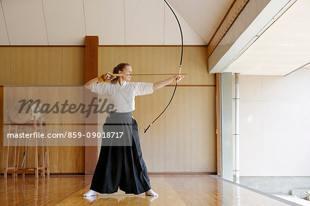 Caucasian woman practicing traditional Kyudo Japanese archery