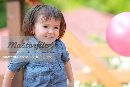 Mixed-race young girl playing with ball on wooden deck