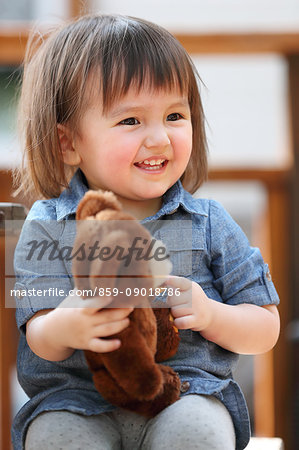 Mixed-race young girl with teddy bear