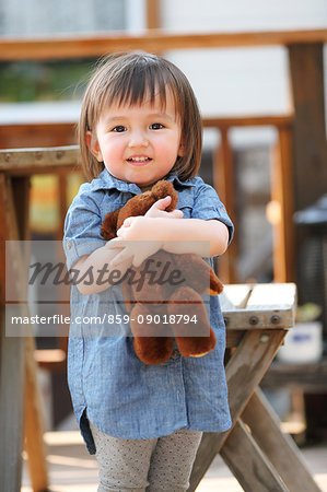 Mixed-race young girl with teddy bear