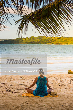 Playa Rincon, Samana Peninsula, Dominican Republic. Woman practicing yoga on the beach.