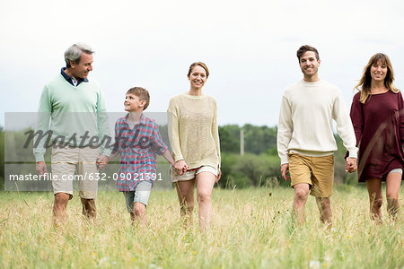 Family walking together through field of tall grass