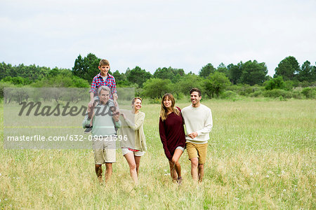 Family walking together through field