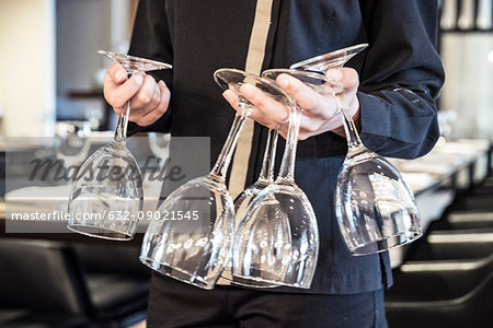 Restaurant worker carrying wineglasses